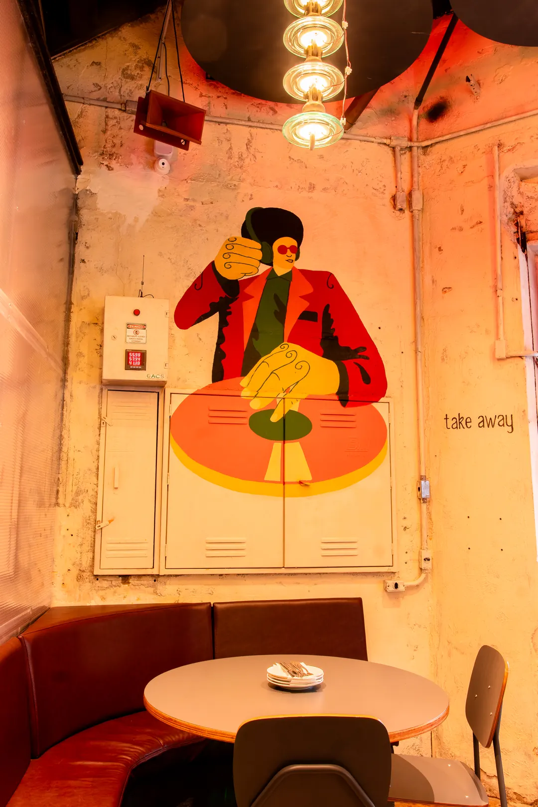 Mural ilustrado e mesa redonda junto ao banco
