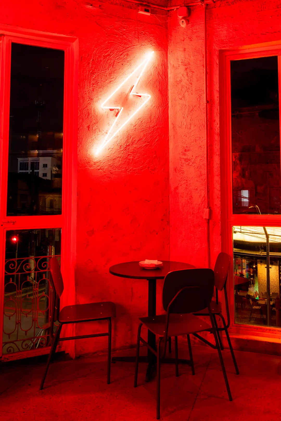 Neon em forma de raio e mesa sob luz vermelha