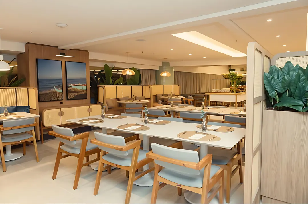 Restaurante do Hotel Bourbon Fortaleza com mesas e cadeiras de madeira