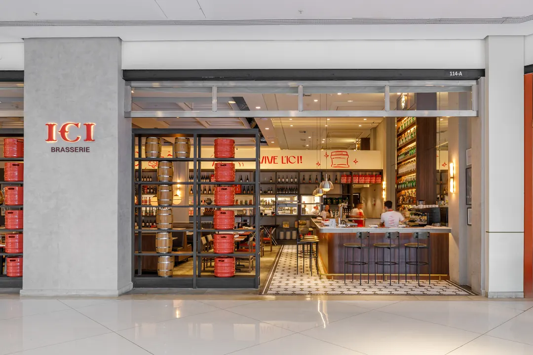 Entrada da ICI Brasserie com vitrine e estantes
