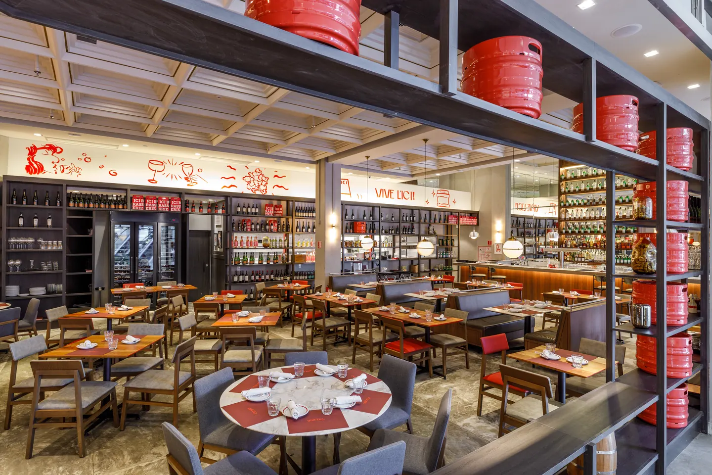 Salão da ICI Brasserie com estantes de caixas vermelhas e mesas