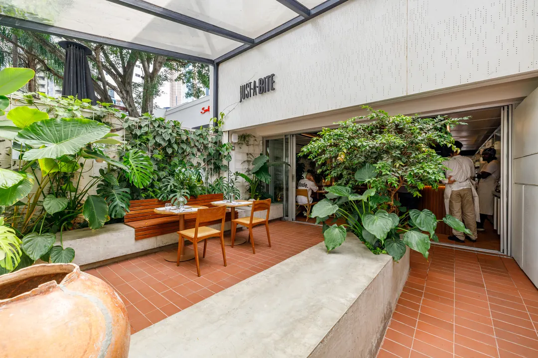 Entrada do Just a Bite com jardim e banco de concreto