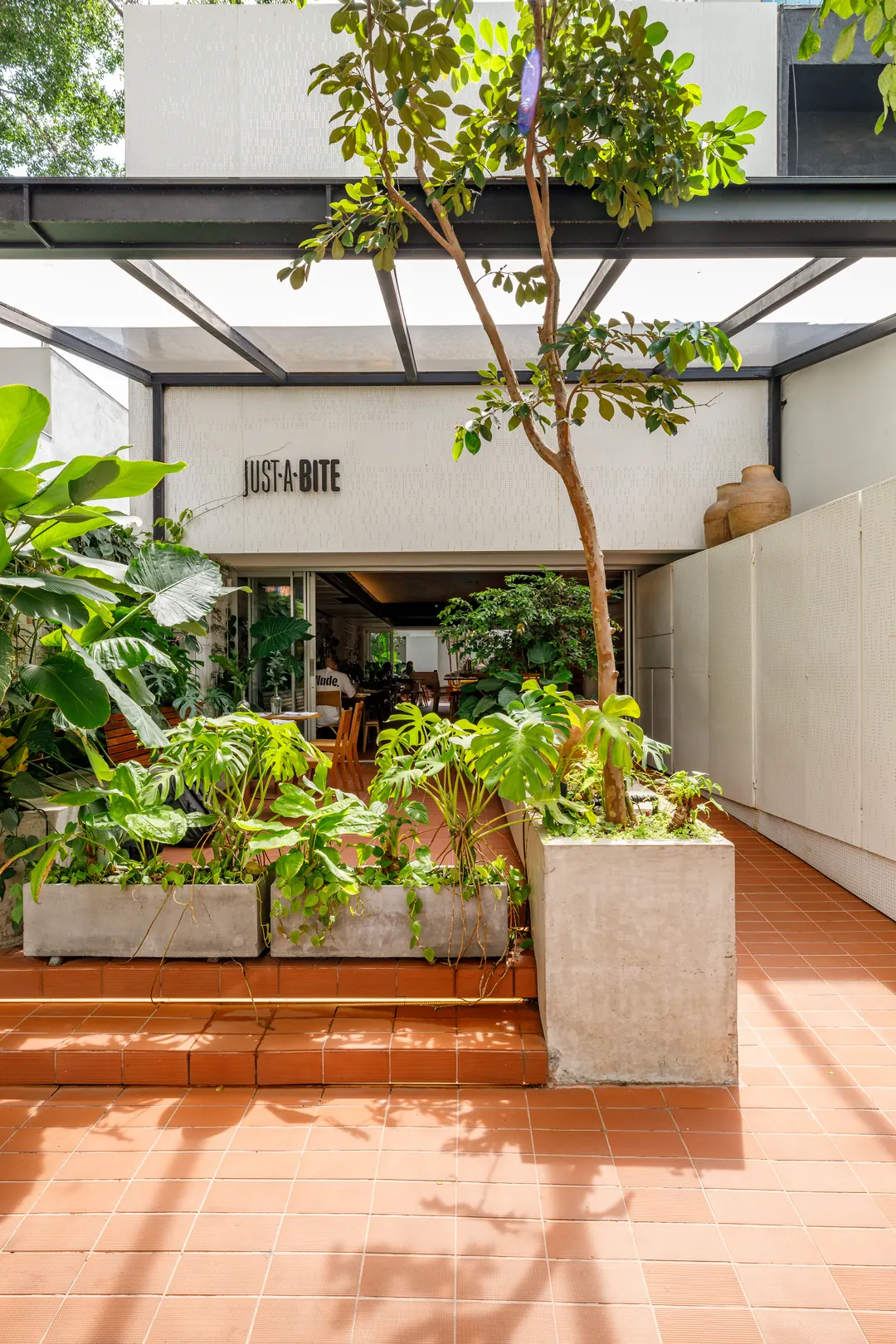 Acesso com jardineiras de concreto e degraus em piso cerâmico
