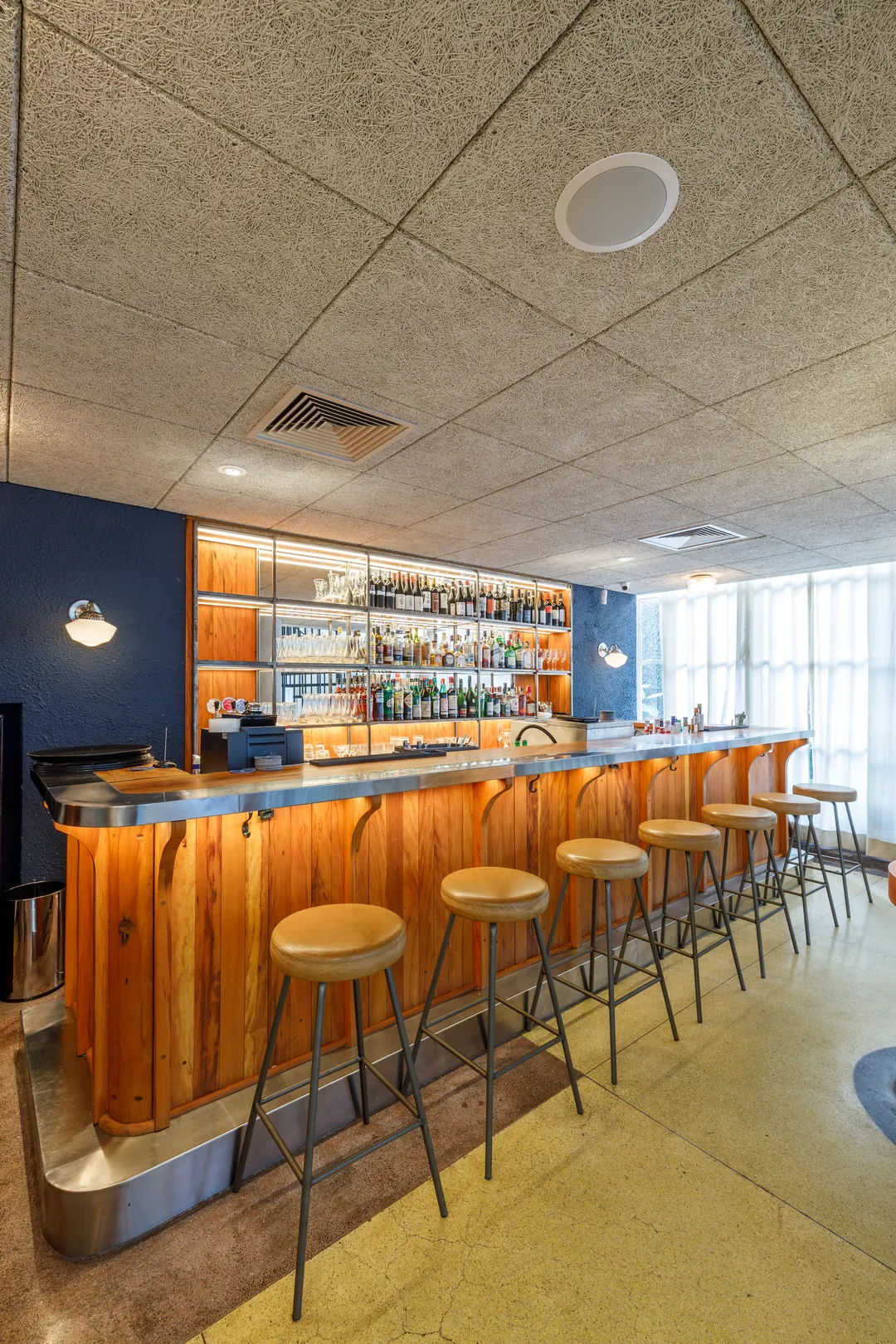 Bar com balcão de madeira e banquetas