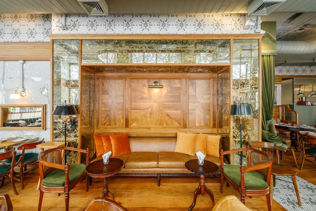 Lounge com poltronas de couro e painel de madeira